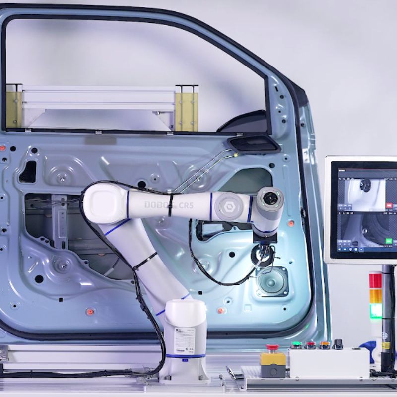 A cobot with a camera tool inspecting a car door, next to a monitor showing the camera views of the inspection points.