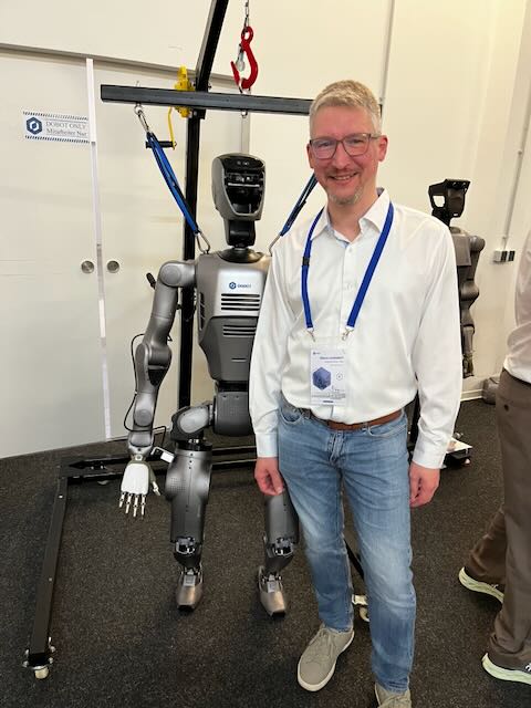 Teilnehmer neben einem humanoiden DOBOT-Roboter auf dem DOBOT-Cobot-Partnermeeting 2026.